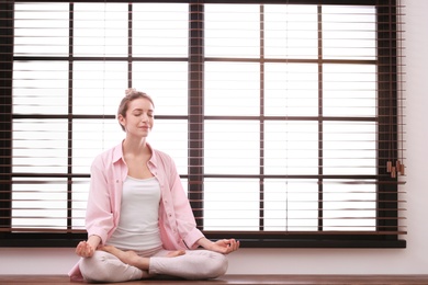 Photo of Young woman meditating at home, space for text. Zen concept