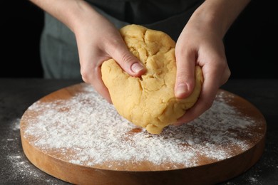 Photo of Making shortcrust pastry. Woman kneading dough at table, closeup