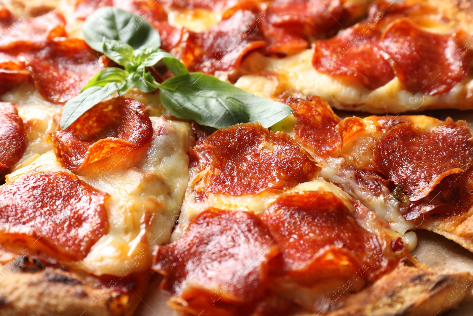 Photo of Tasty pepperoni pizza with basil on table, closeup