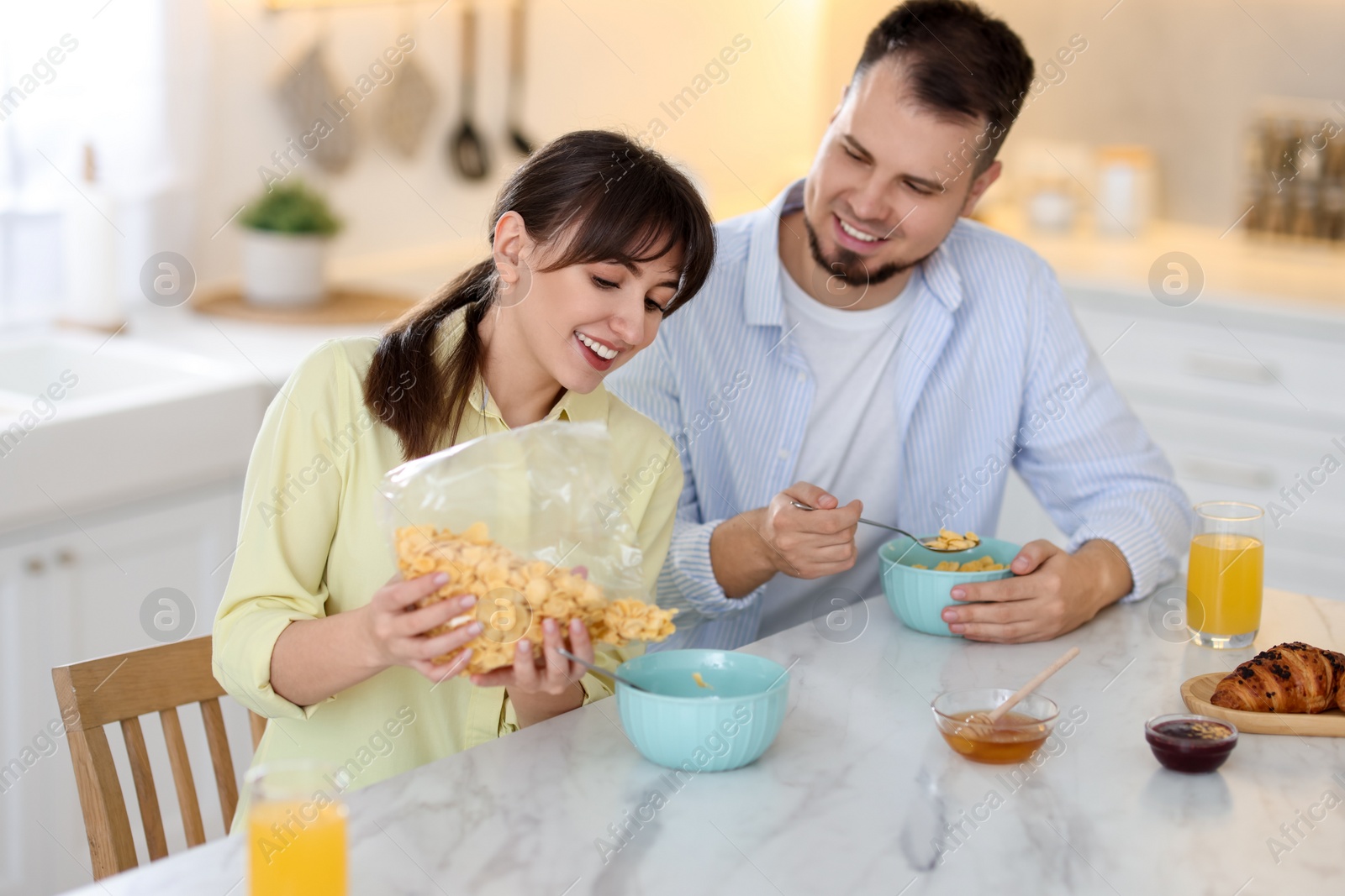 Photo of Happy couple having tasty breakfast at home