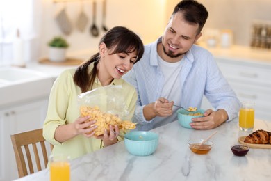 Happy couple having tasty breakfast at home