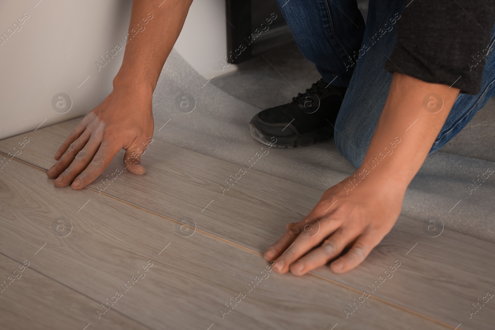 Photo of Professional worker installing new laminate flooring indoors