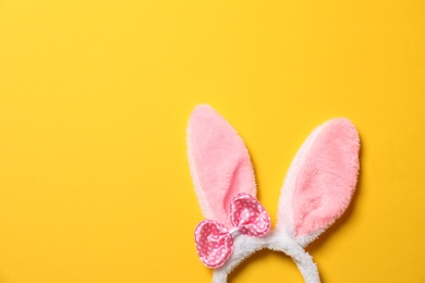 Photo of Funny headband with Easter bunny ears on color background, top view. Space for text