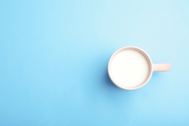 Photo of Cup of fresh milk on color background, top view. Space for text