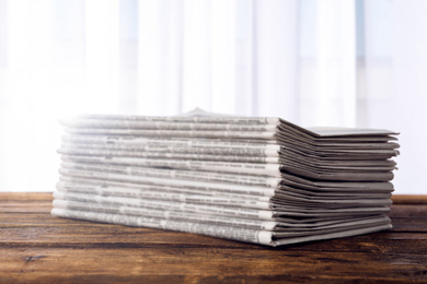 Stack of newspapers on wooden table. Journalist's work