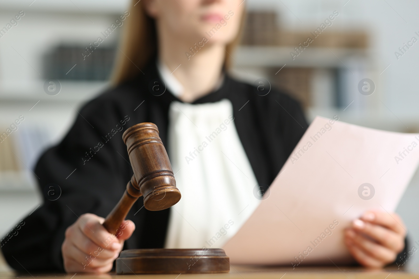 Photo of Judge striking mallet at table indoors, closeup