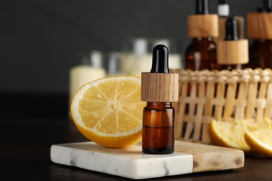 Bottle of essential oil and lemon on wooden table