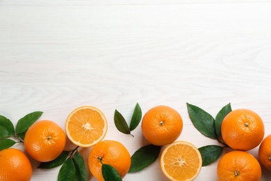 Photo of Delicious ripe oranges on white wooden table, flat lay. Space for text