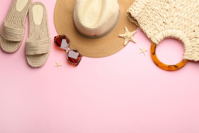 Photo of Beach accessories on pink background, flat lay. Space for text