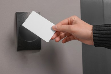 Photo of Woman opening magnetic door lock with key card, closeup. Home security