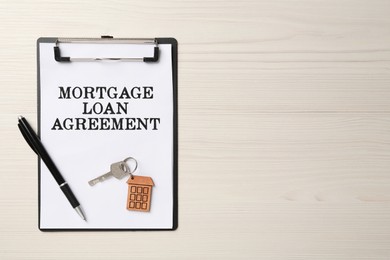 Image of Mortgage loan agreement, house key and pen on white wooden table, top view. Space for text