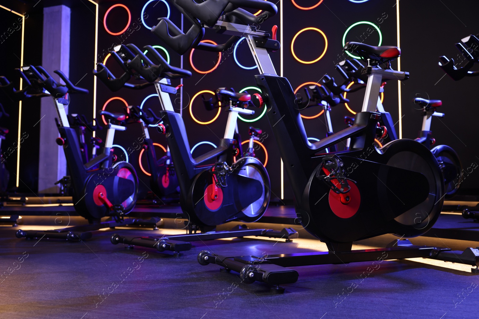 Photo of Many exercise bikes in fitness club. Indoor cycling class