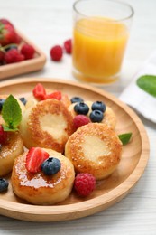 Delicious cottage cheese pancakes with fresh berries and honey on white wooden table, closeup