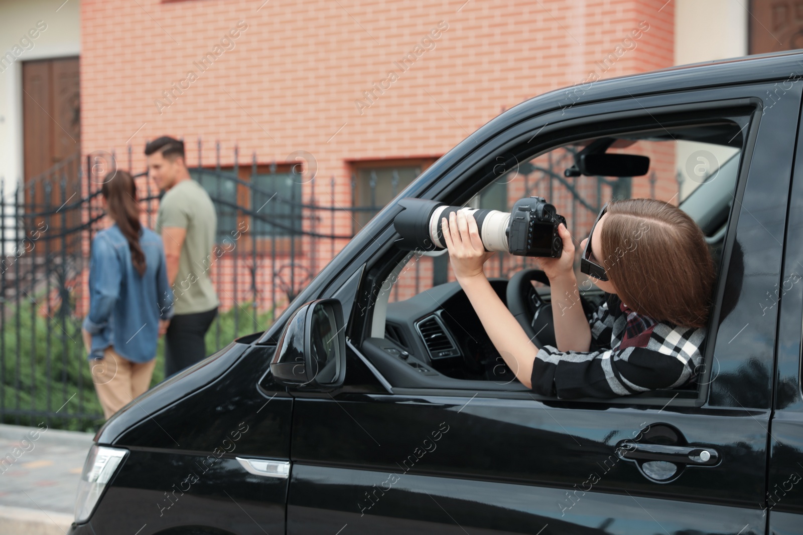 Photo of Private detective with camera spying from car