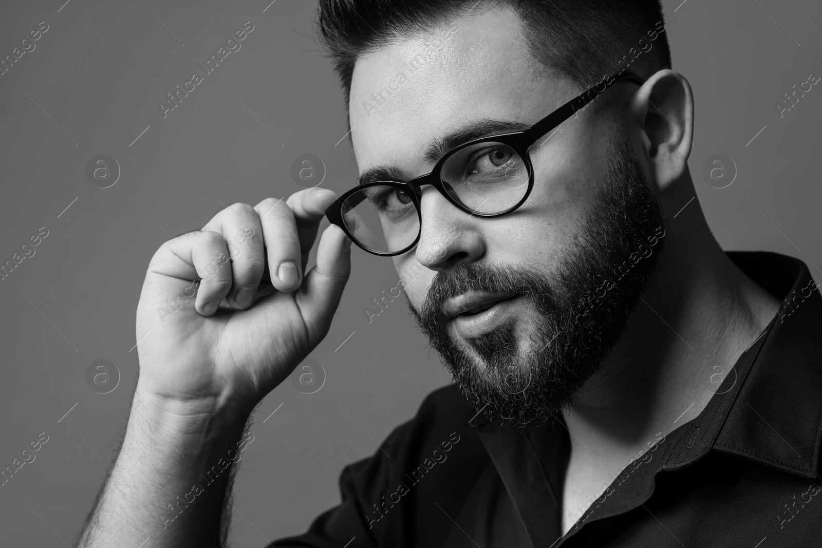 Photo of Portrait of handsome bearded man on grey background. Black and white effect