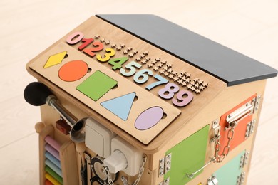 Photo of Busy board house indoors, closeup. Baby sensory toy