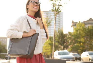 Young woman with stylish shopper bag outdoors. Space for text