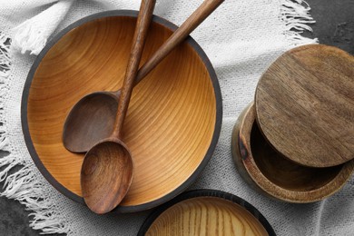 Photo of Stylish wooden dishware and spoons on grey table, flat lay