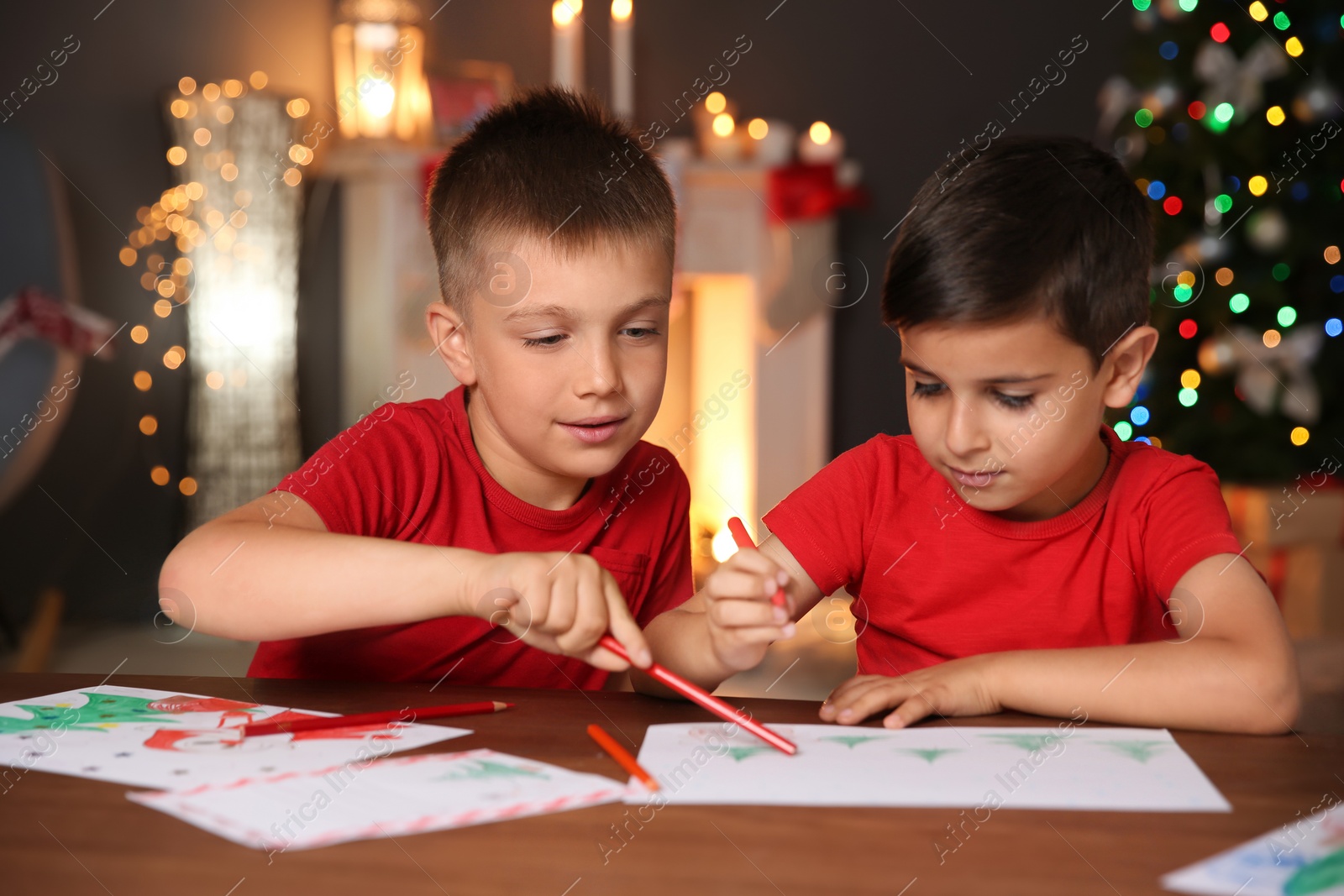 Photo of Little children drawing pictures at home. Christmas celebration