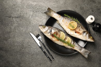 Photo of Delicious baked fish served on grey table, flat lay. Space for text