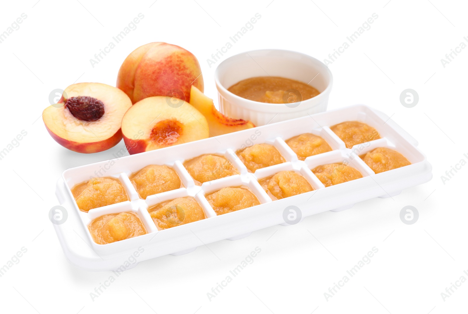 Photo of Nectarine puree in ice cube tray and fresh nectarine fruits isolated on white. Ready for freezing