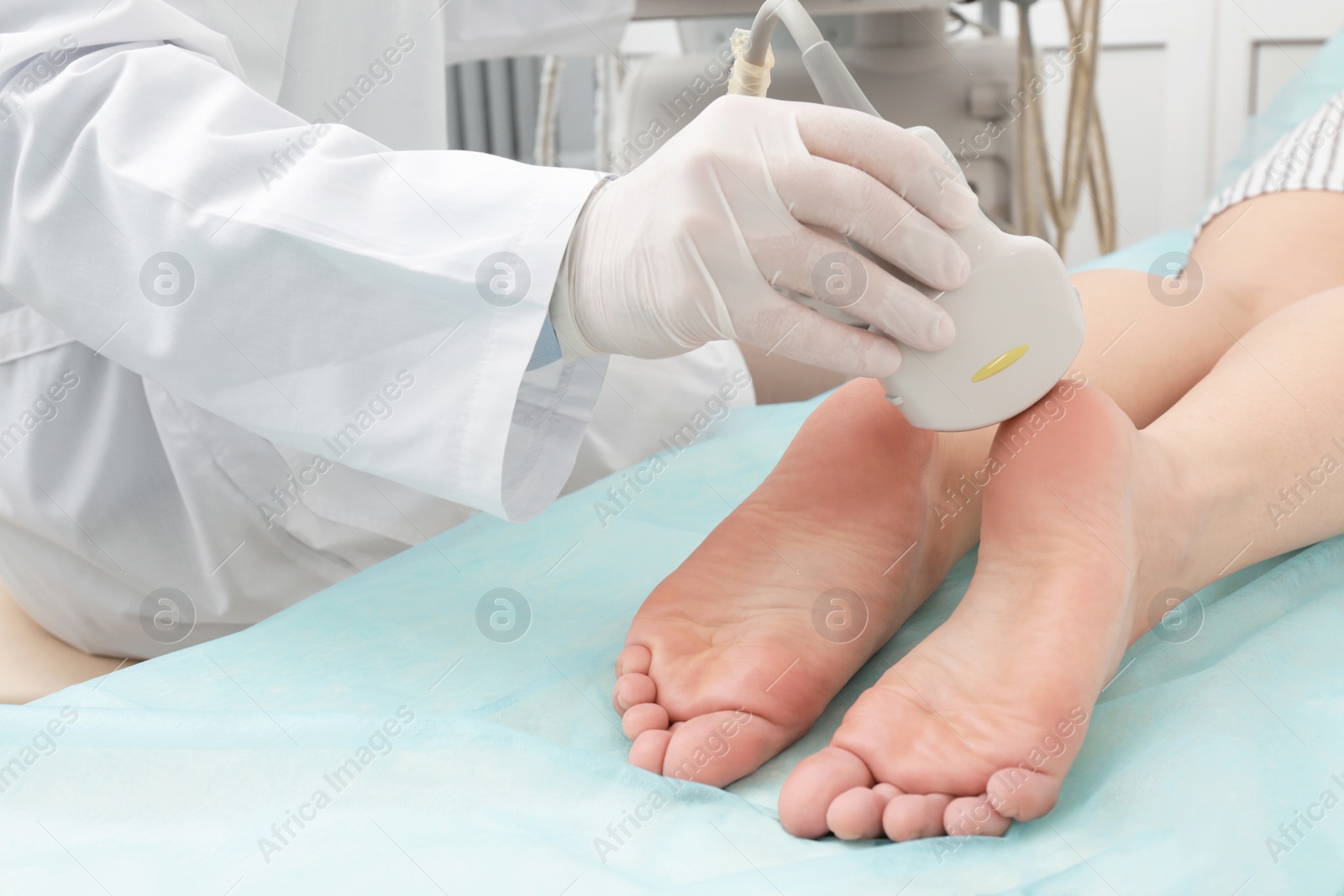 Photo of Doctor conducting ultrasound examination of patient's foot in clinic, closeup