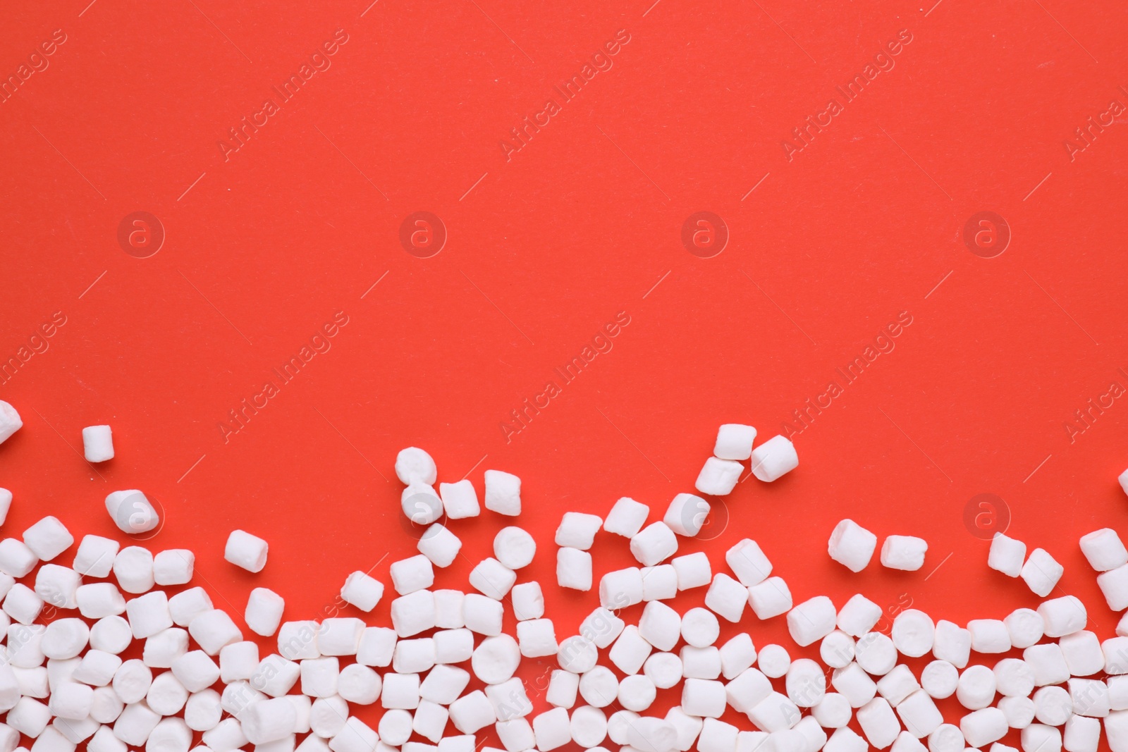 Photo of Delicious marshmallows on red background, flat lay. Space for text