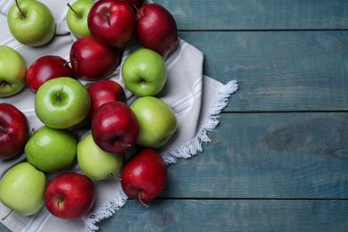 Photo of Fresh ripe red and green apples on light blue wooden table, flat lay, Space for text