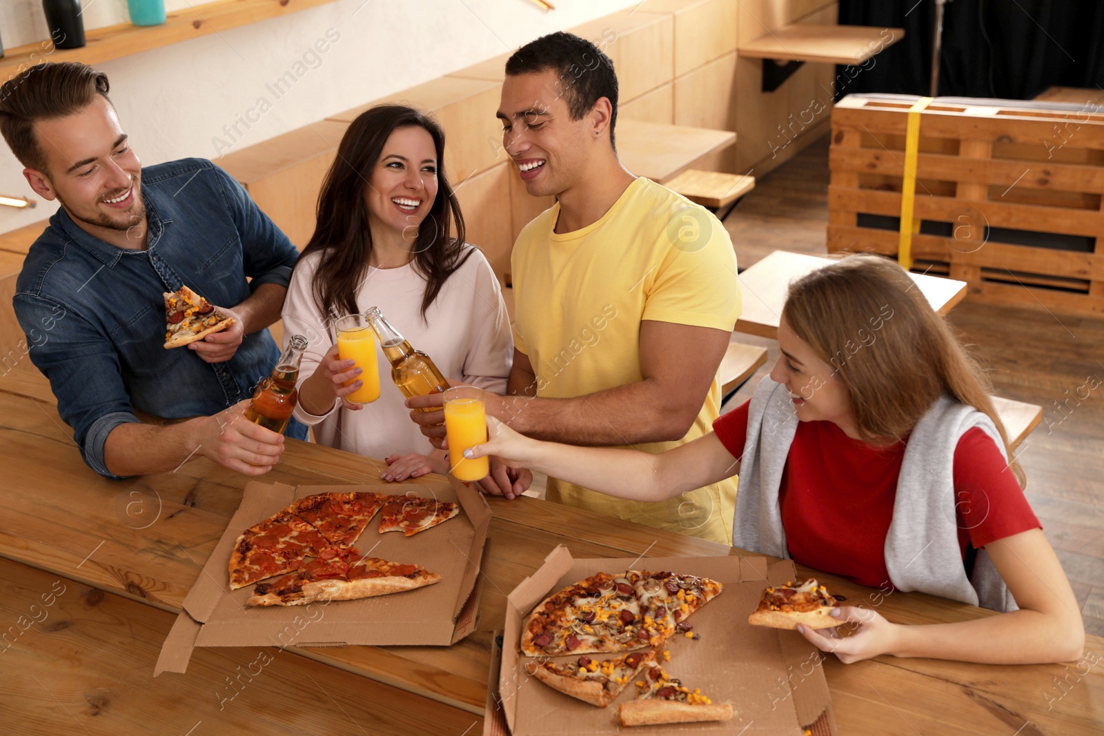 Photo of Group of friends having fun party with delicious pizza in cafe