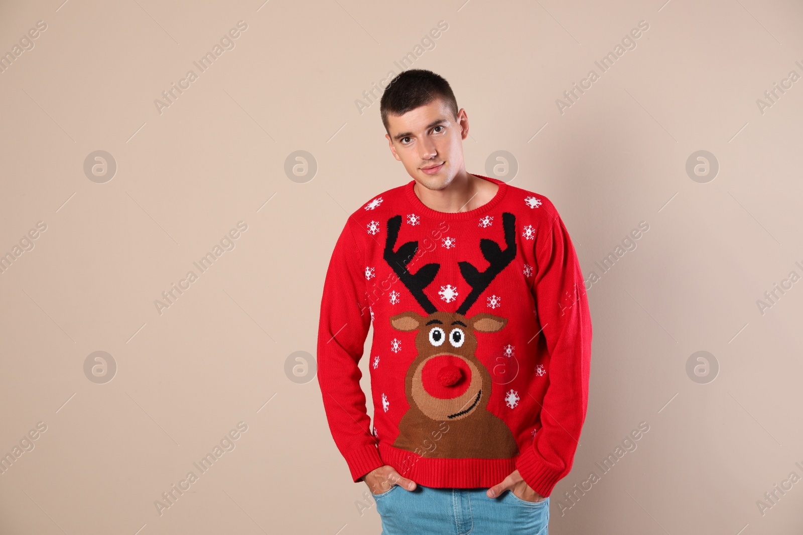 Photo of Portrait of happy man in Christmas sweater on beige background