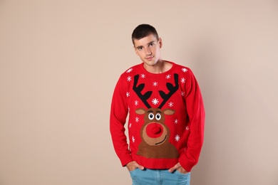 Portrait of happy man in Christmas sweater on beige background