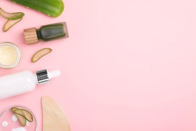 Cosmetic products, cut aloe leaves and gua sha tool on pink background, flat lay. Space for text