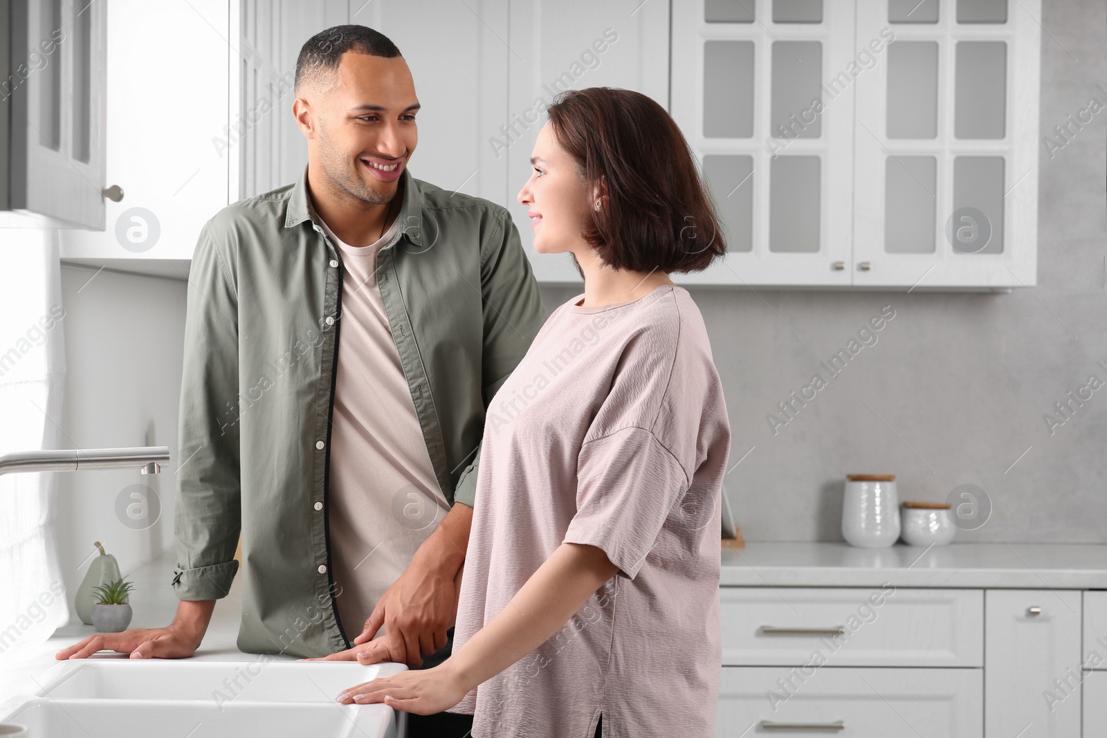 Photo of Dating agency. Happy couple spending time together in kitchen, space for text