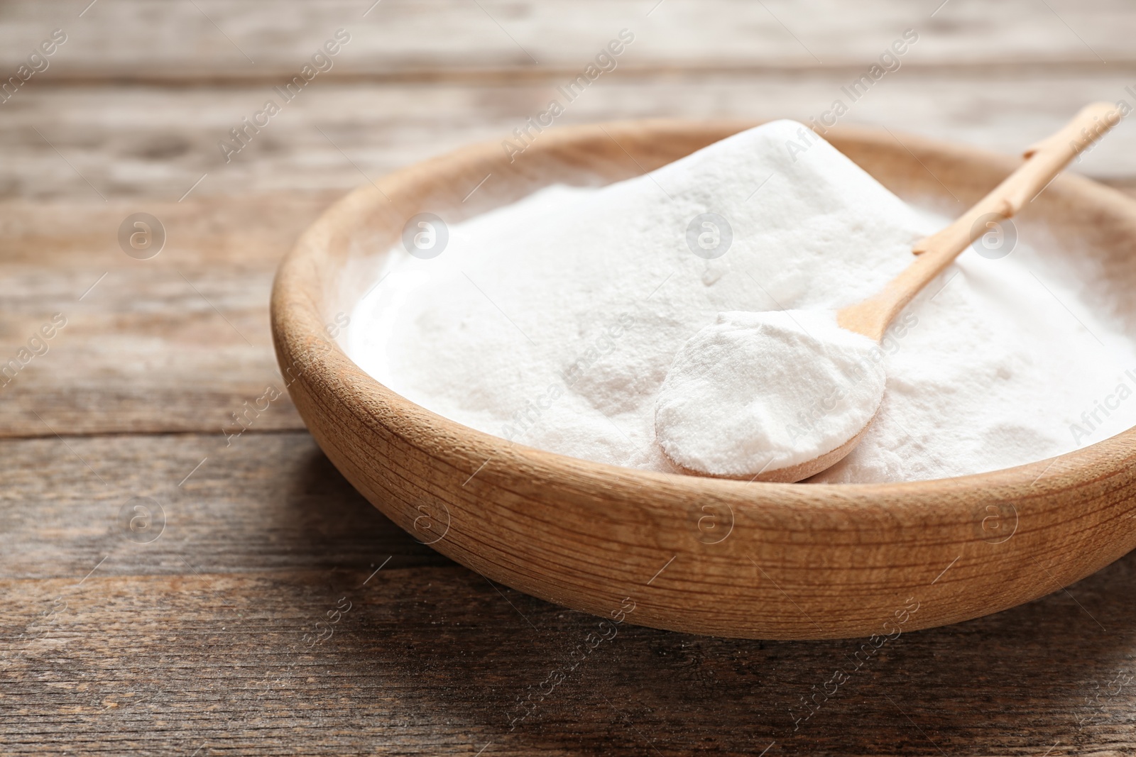 Photo of Plate with baking soda on wooden background