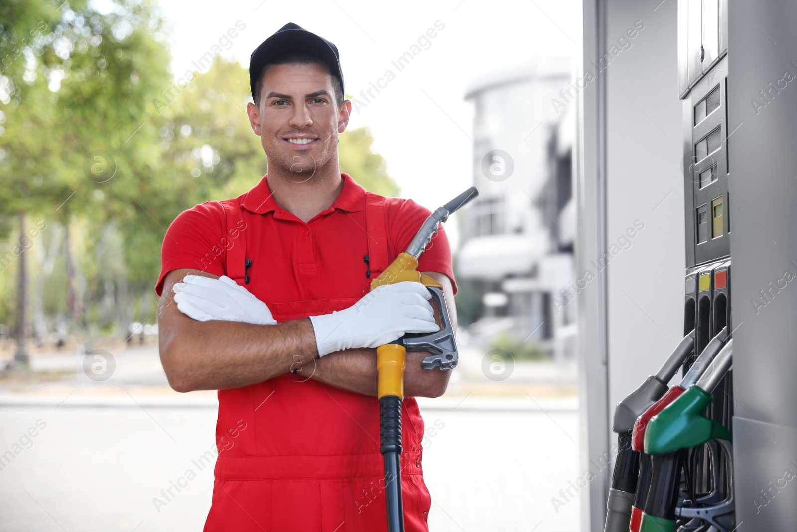 Photo of Worker with fuel pump nozzle at modern gas station