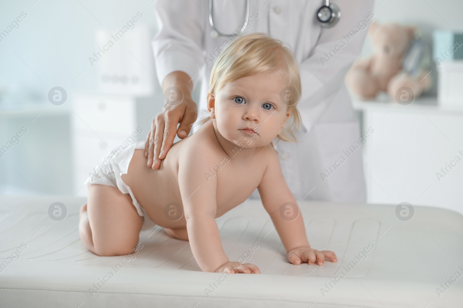 Photo of Pediatrician examining baby in hospital. Health care