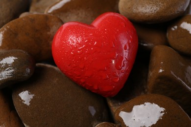 Photo of Red decorative heart on stones, closeup view