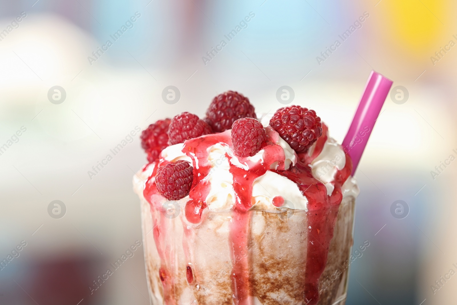 Photo of Tasty milk shake with topping on blurred background, closeup