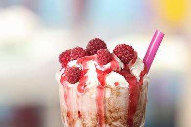 Tasty milk shake with topping on blurred background, closeup