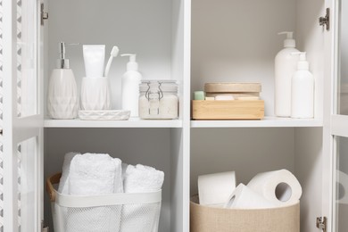 Photo of Different personal care products and bath accessories in bathroom vanity