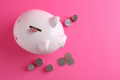 Photo of Financial savings. Piggy bank and coins on pink background, flat lay with space for text