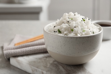 Bowl of tasty cooked rice served on table. Space for text