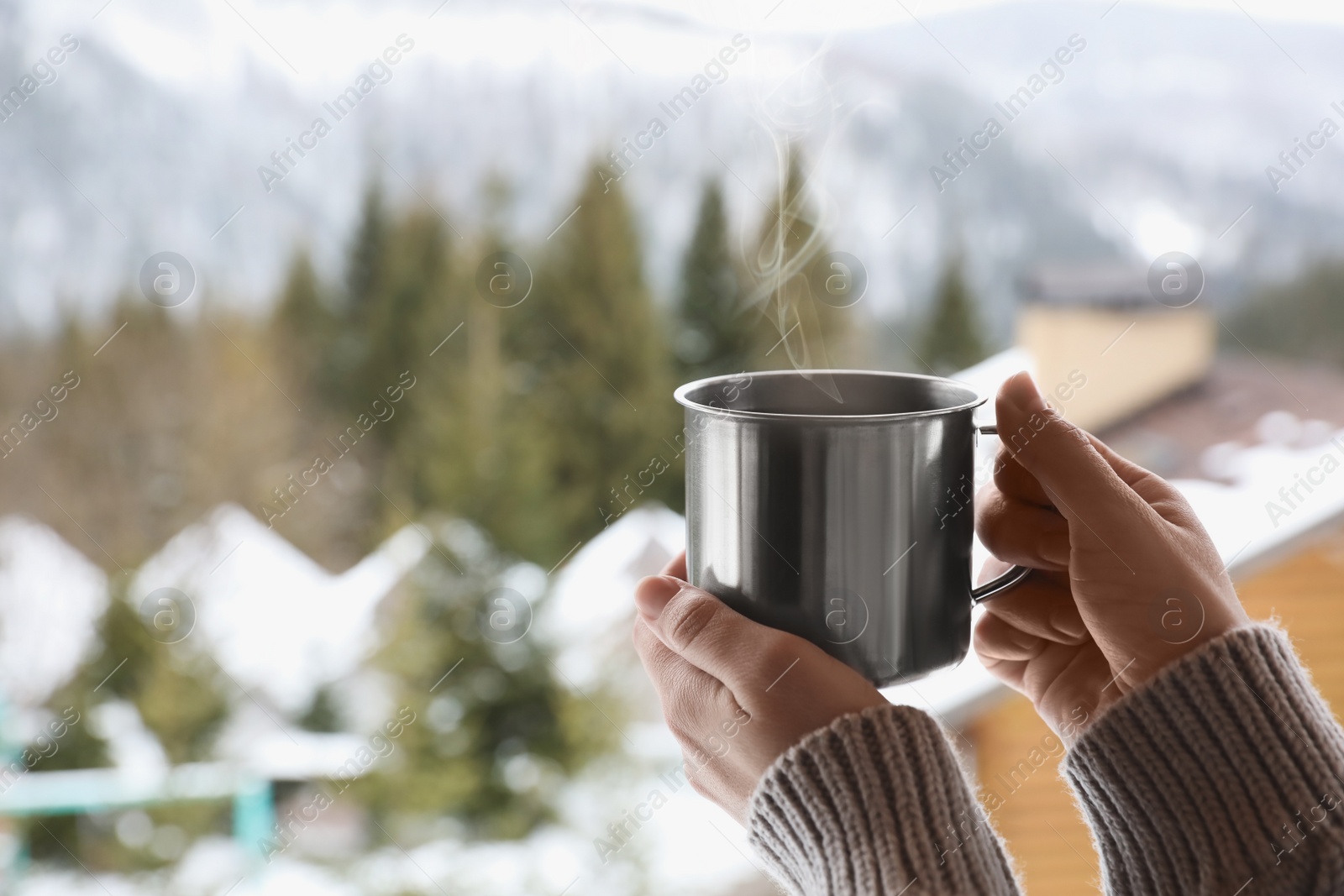 Photo of Woman with cup of tasty coffee outdoors on winter morning, closeup