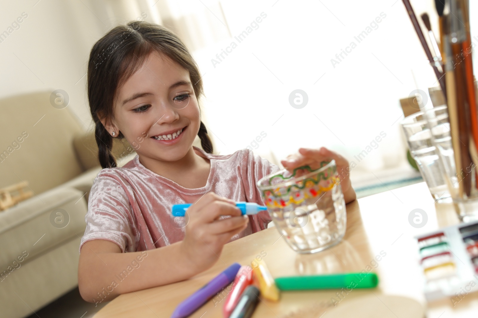 Photo of Little girl painting glass at table indoors. Creative hobby