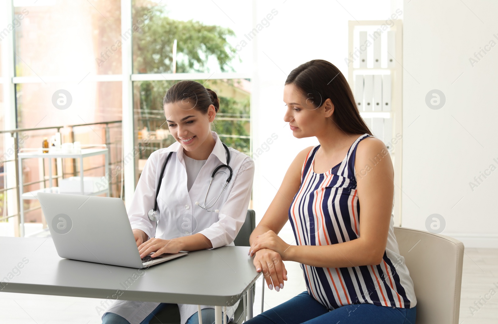 Photo of Young doctor consulting patient in modern hospital