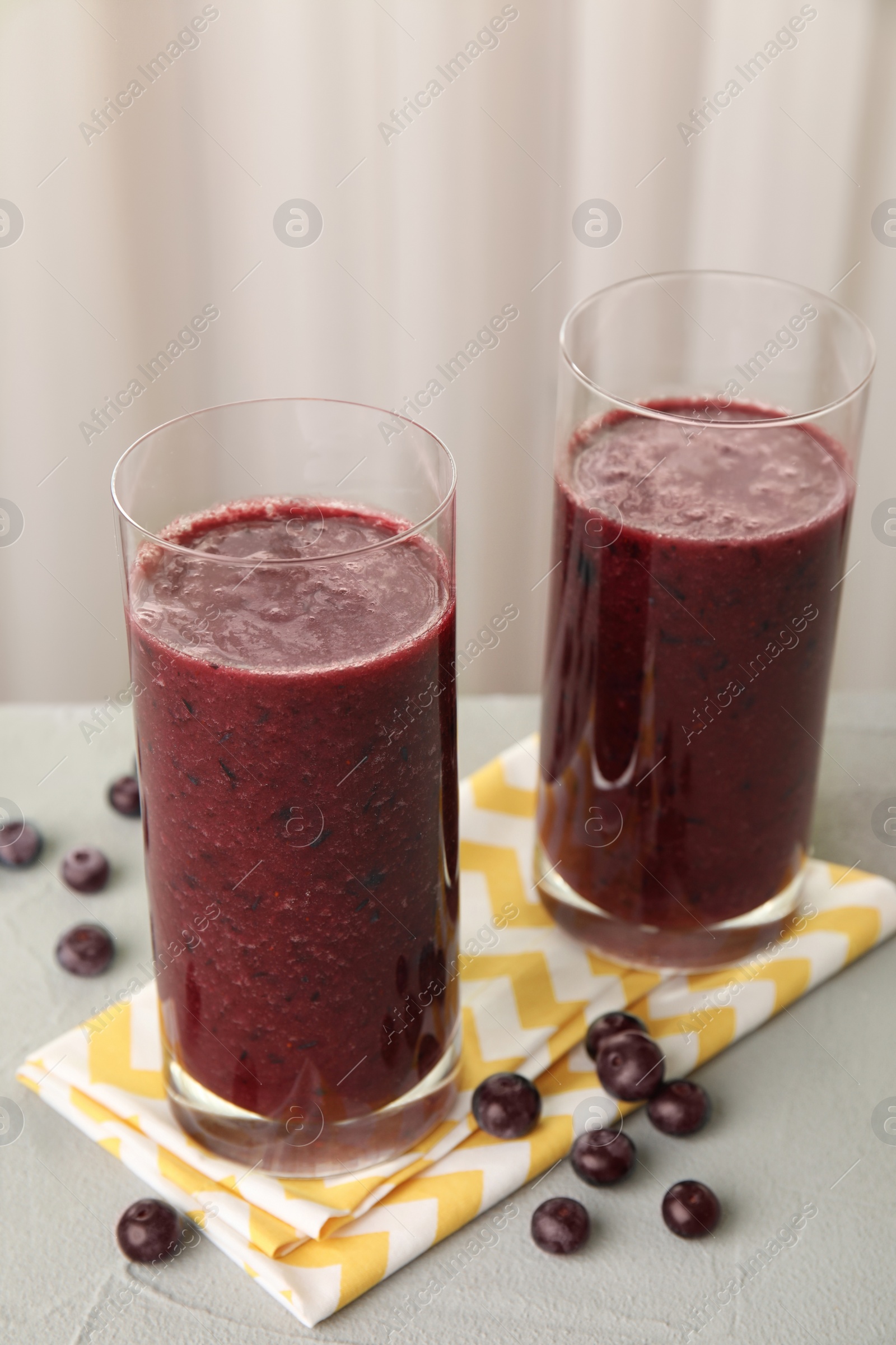 Photo of Glasses with delicious acai smoothie on table