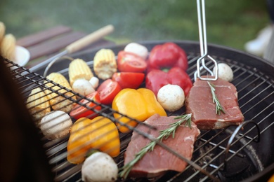 Photo of Cooking fresh food on barbecue grill outdoors, closeup