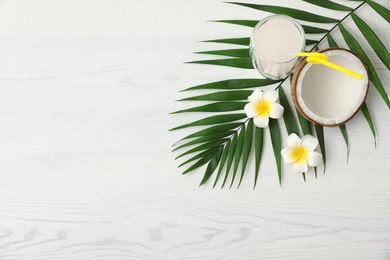 Photo of Flat lay composition with glass of coconut water on white wooden background. Space for text