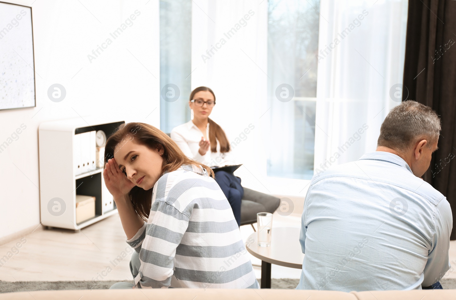 Photo of Psychotherapist working with couple in office. Family counselling