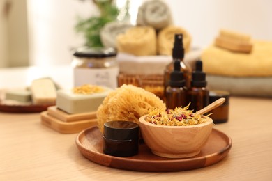 Photo of Dry flowers, loofah and jar of cream on wooden table, space for text. Spa time